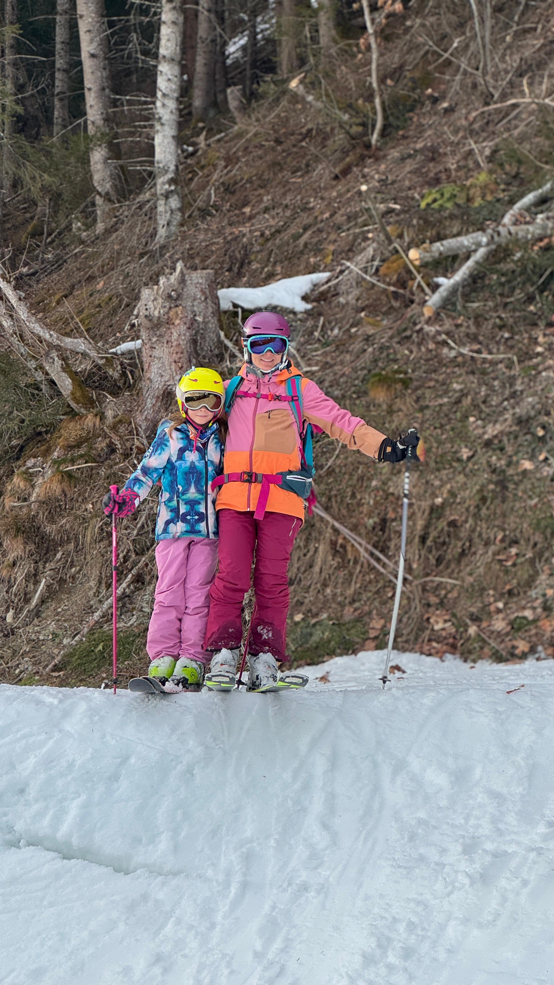 Csilla with a young skier beside a forest slope