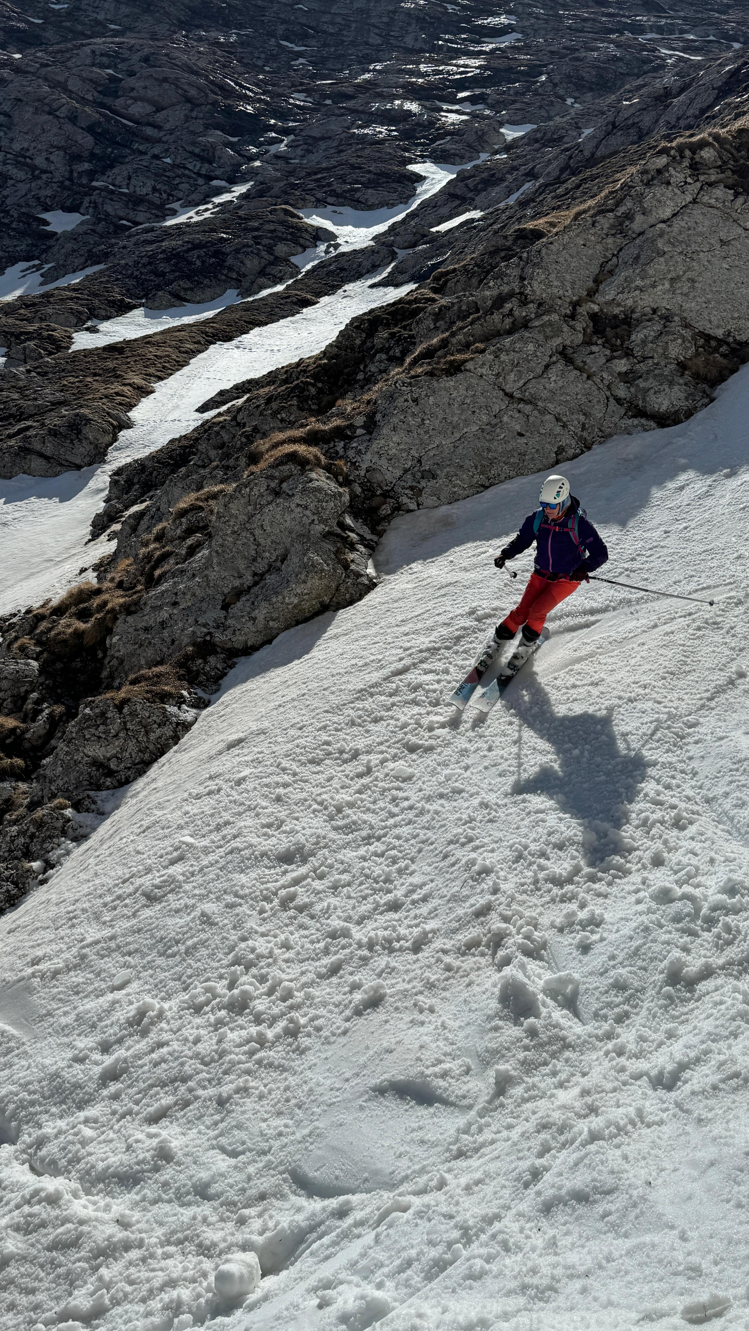 A skier descending steep high-mountain snow